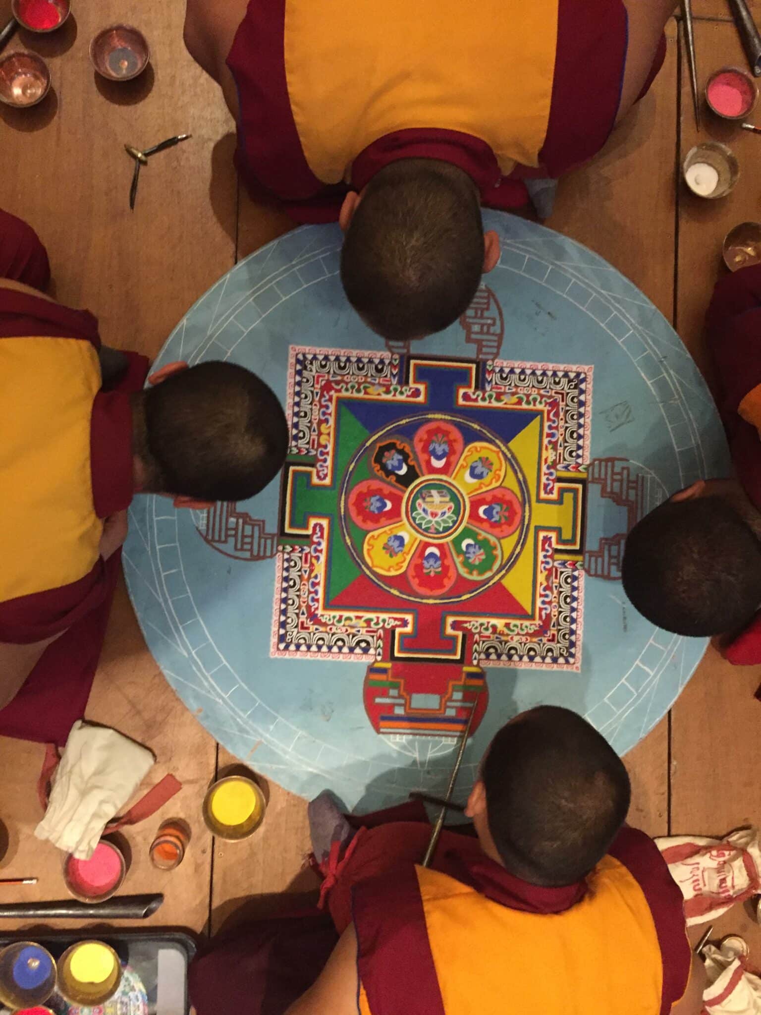 Moines tibétains vus de haut autour du mandala de sable