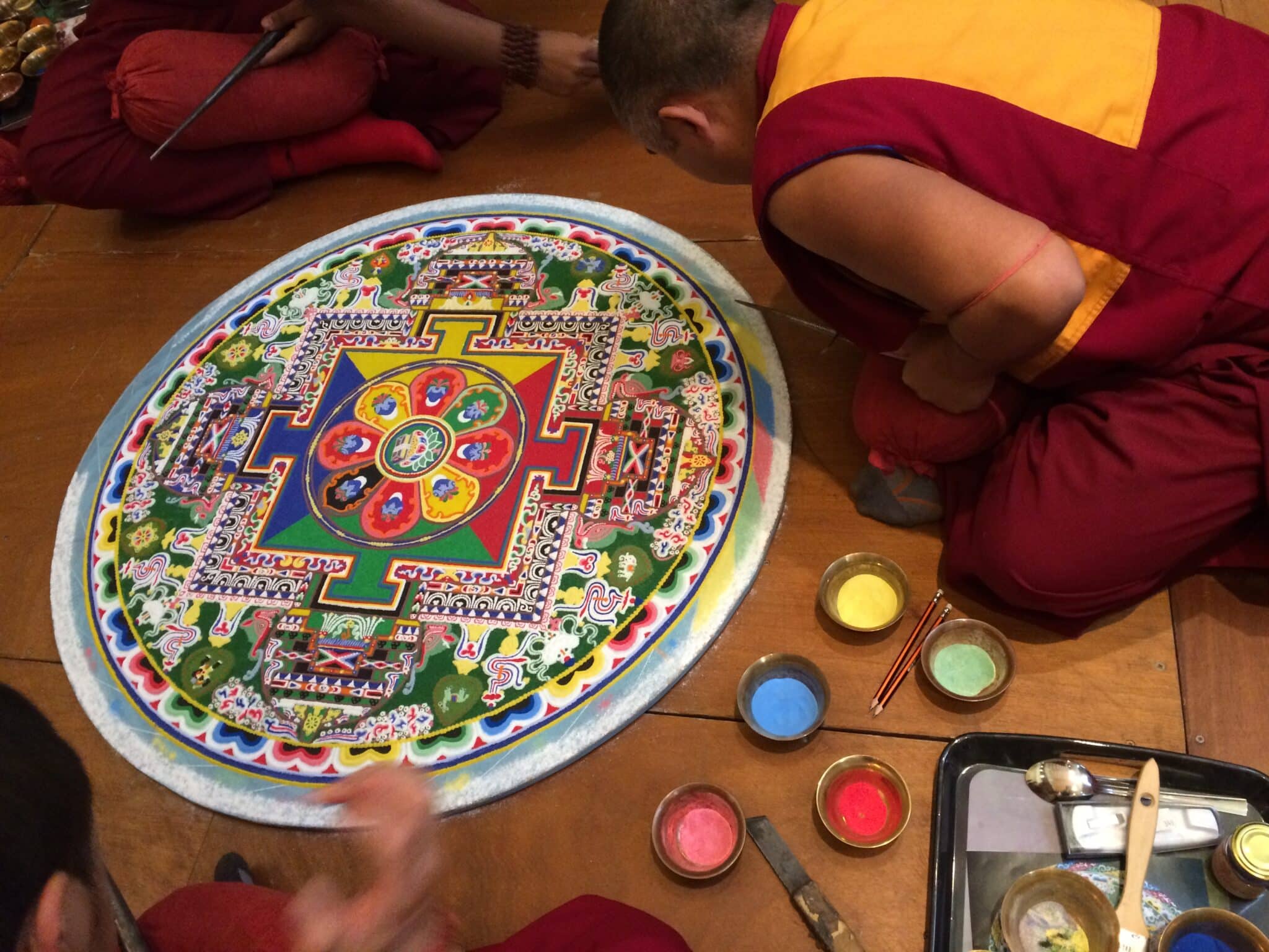 Moines tibétains réalisant un mandala de sable